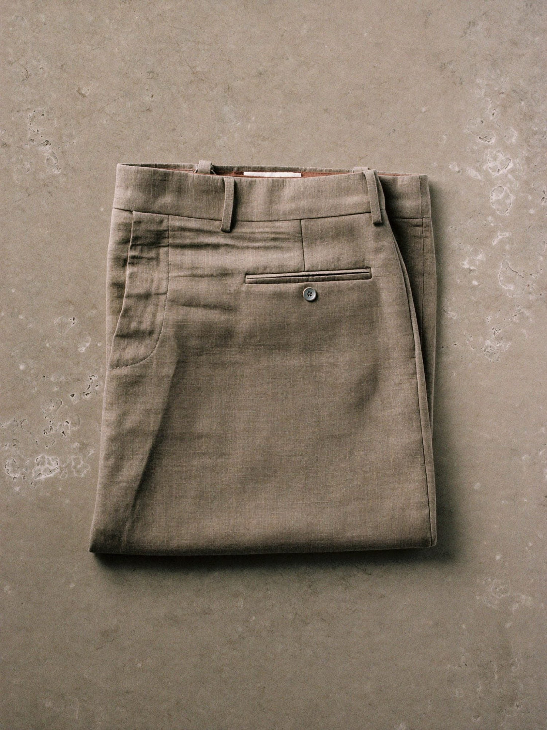 Folded neutral trousers laid flat